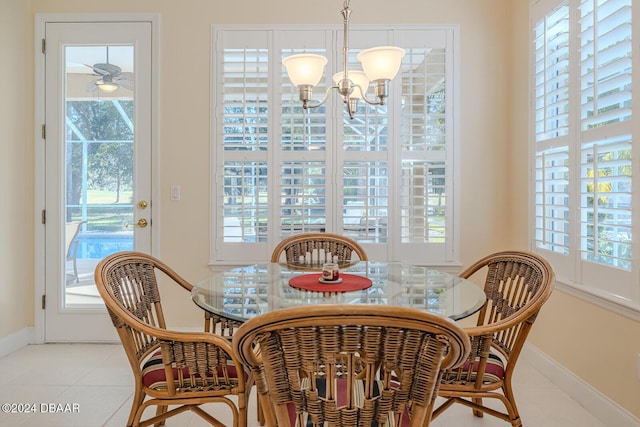 dining space with a healthy amount of sunlight, light tile patterned flooring, and a chandelier