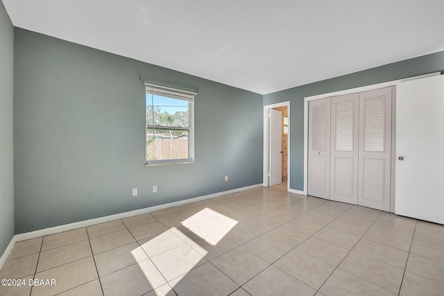 unfurnished bedroom with light tile patterned floors and a closet