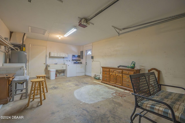 garage featuring a garage door opener, sink, and washer and clothes dryer