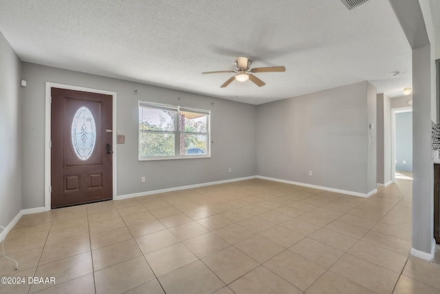 tiled entrance foyer featuring a textured ceiling and ceiling fan