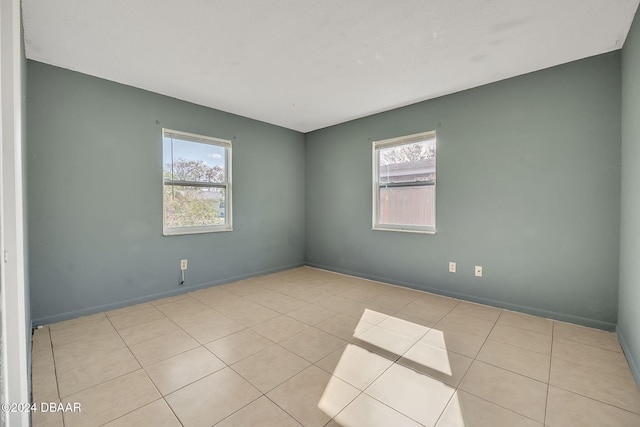 empty room with a healthy amount of sunlight and light tile patterned flooring