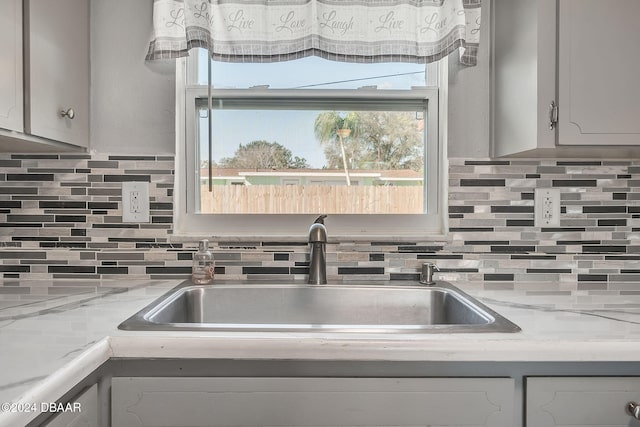 kitchen with tasteful backsplash, a wealth of natural light, and sink