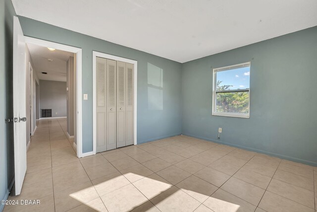 unfurnished bedroom featuring a closet and light tile patterned floors