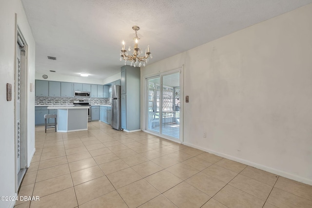 kitchen featuring stainless steel appliances, a breakfast bar, an inviting chandelier, backsplash, and a kitchen island