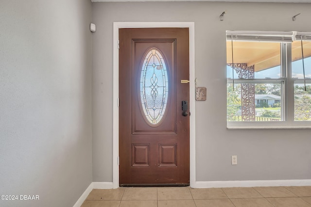 entryway with a wealth of natural light and light tile patterned floors