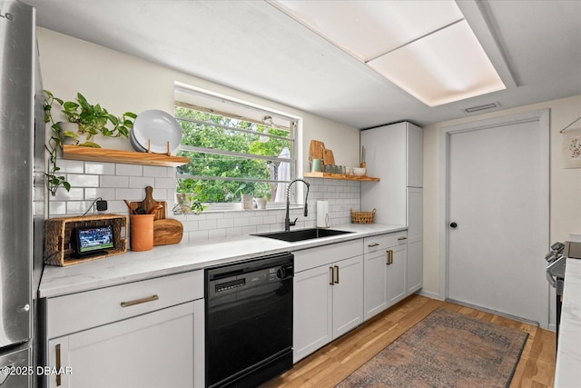 kitchen with open shelves, light wood-style floors, black appliances, backsplash, and a sink