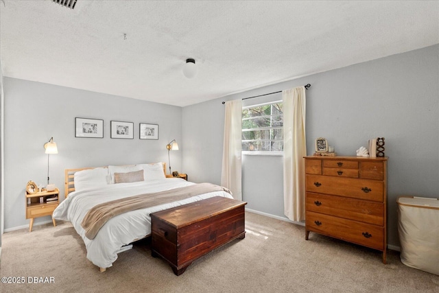 bedroom with a textured ceiling and light colored carpet