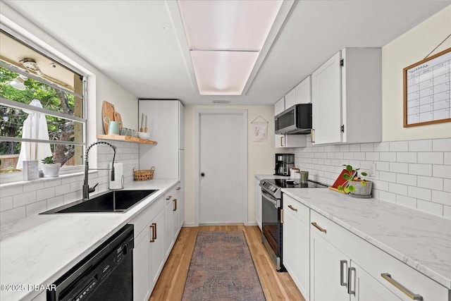 kitchen with open shelves, light wood-style floors, appliances with stainless steel finishes, a sink, and white cabinetry
