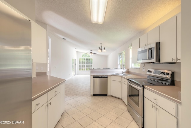 19 Meadow Ridge Vw, Ormond Beach, FL 32174 - kitchen with stainless steel appliances, a peninsula, a textured ceiling, open floor plan, and light tile patterned floors
