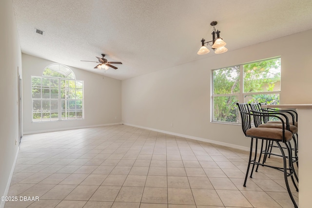 19 Meadow Ridge Vw, Ormond Beach, FL 32174 - empty room with plenty of natural light, ceiling fan, a textured ceiling, lofted ceiling, and light tile patterned floors