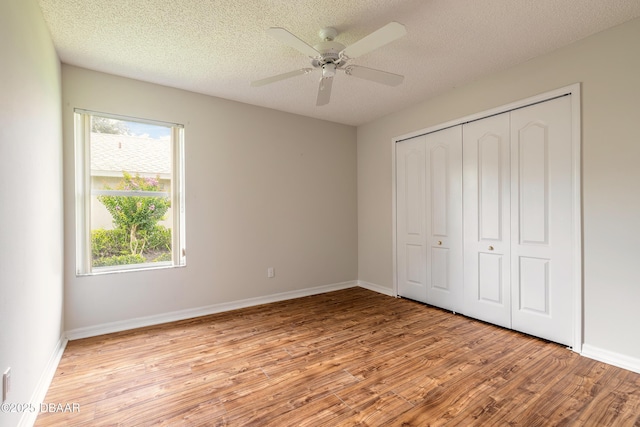 19 Meadow Ridge Vw, Ormond Beach, FL 32174 - unfurnished bedroom featuring light wood-style floors, multiple windows, a closet, and a textured ceiling