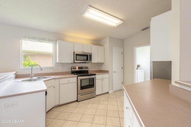 19 Meadow Ridge Vw, Ormond Beach, FL 32174 - kitchen featuring stainless steel appliances, a textured ceiling, white cabinetry, light tile patterned floors, and light countertops
