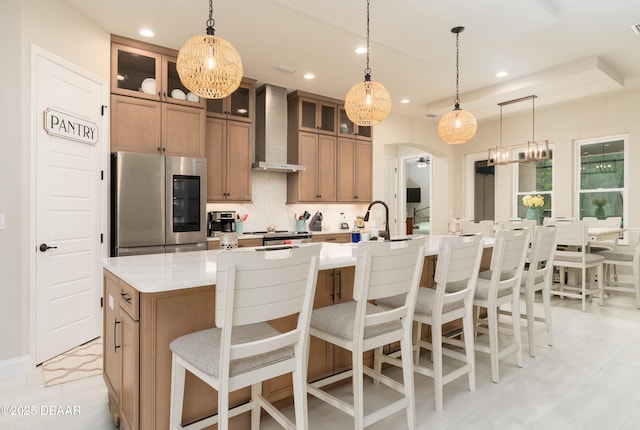 150 Portofino Blvd, New Smyrna Beach, FL 32168 - kitchen with smart refrigerator, wall chimney range hood, arched walkways, a spacious island, and light countertops