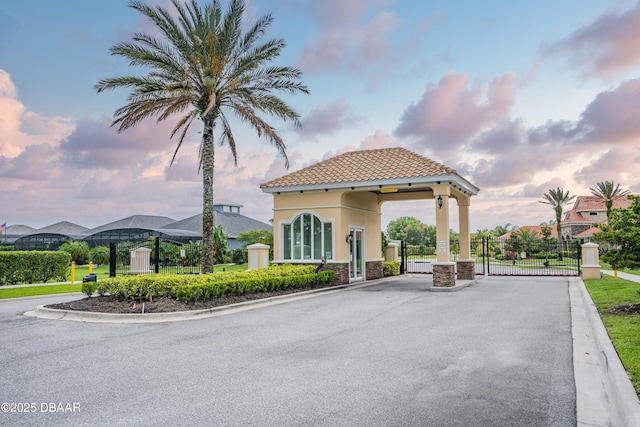 150 Portofino Blvd, New Smyrna Beach, FL 32168 - view of asphalt road with a gate, a gated entry, and curbs
