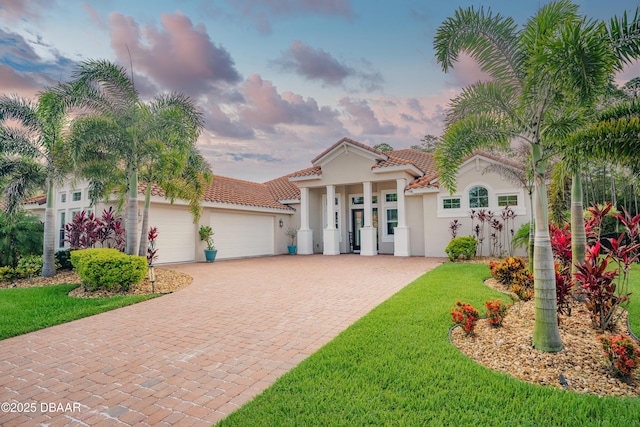 150 Portofino Blvd, New Smyrna Beach, FL 32168 - mediterranean / spanish-style house with stucco siding, decorative driveway, a garage, and a front lawn
