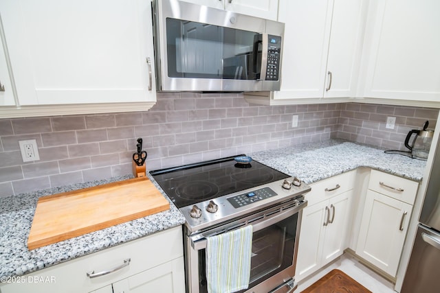 76 Longridge Ln, Ormond Beach, FL 32174 - kitchen featuring stainless steel appliances, backsplash, and white cabinetry