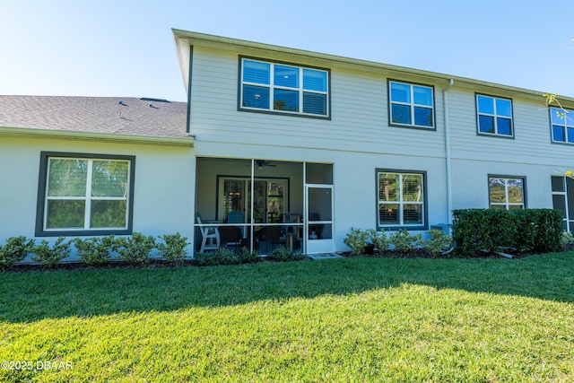 rear view of property featuring a lawn