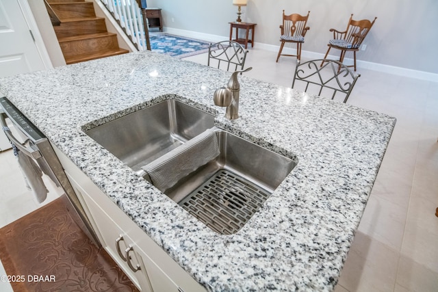 76 Longridge Ln, Ormond Beach, FL 32174 - kitchen view of a sink, light stone counters, and baseboards