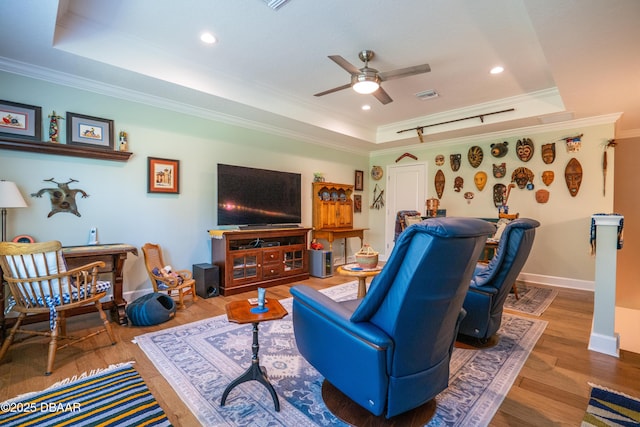 living room featuring a tray ceiling, ornamental molding, and hardwood / wood-style floors