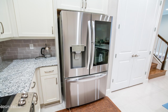 76 Longridge Ln, Ormond Beach, FL 32174 - kitchen featuring stainless steel fridge, white cabinetry, tasteful backsplash, and light stone countertops