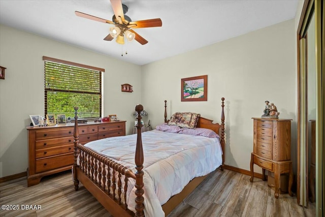 bedroom with ceiling fan, wood finished floors, and baseboards