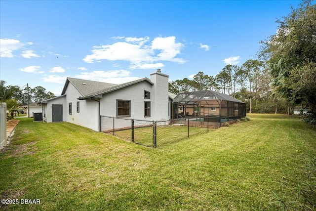 rear view of property featuring glass enclosure, a lawn, fence, and stucco siding