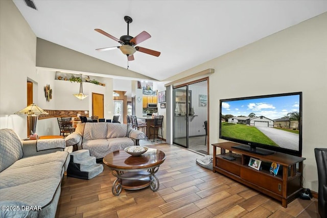 living area with a ceiling fan, light wood-type flooring, visible vents, and vaulted ceiling