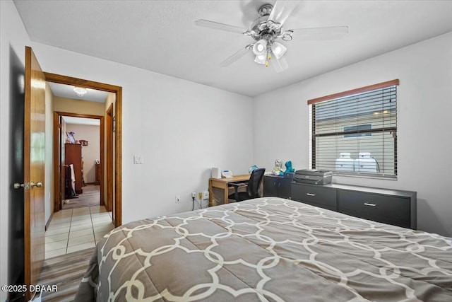 tiled bedroom featuring ceiling fan