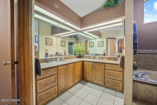 bathroom with double vanity, a garden tub, a sink, and tile patterned floors