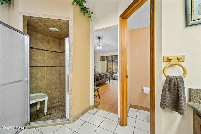 full bath featuring tile patterned flooring, baseboards, a shower stall, and vanity