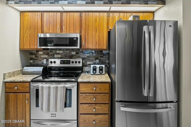 kitchen featuring appliances with stainless steel finishes, brown cabinetry, and decorative backsplash