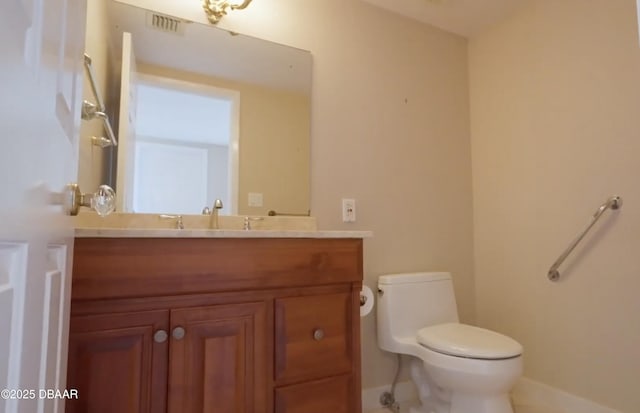 bathroom featuring toilet, visible vents, and vanity