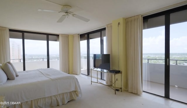 bedroom with access to exterior, ceiling fan, and a wall of windows