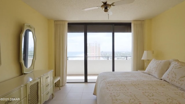 bedroom with floor to ceiling windows, light tile patterned floors, ceiling fan, a textured ceiling, and access to outside