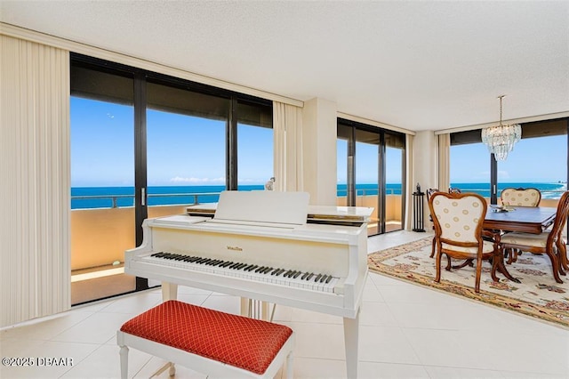 interior space featuring a water view, light tile patterned floors, expansive windows, and a chandelier