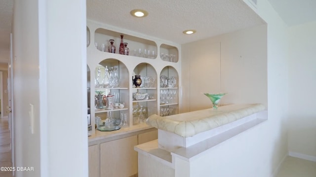 bar featuring a textured ceiling and recessed lighting