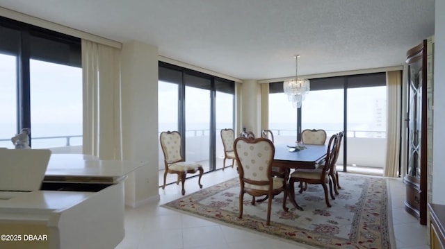 dining area with a healthy amount of sunlight, floor to ceiling windows, a textured ceiling, and an inviting chandelier