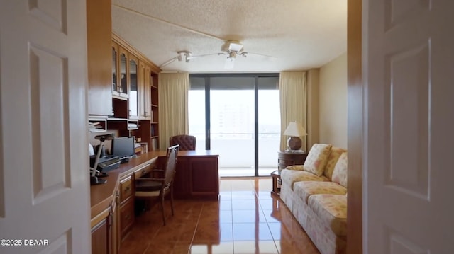 office featuring ceiling fan, floor to ceiling windows, a textured ceiling, and light tile patterned flooring