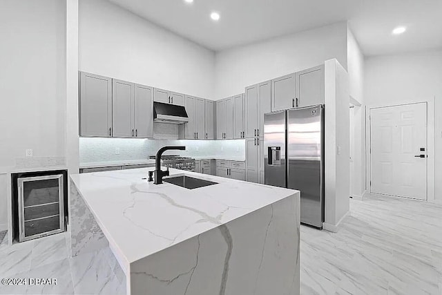 kitchen featuring wine cooler, light stone counters, a high ceiling, and stainless steel refrigerator with ice dispenser