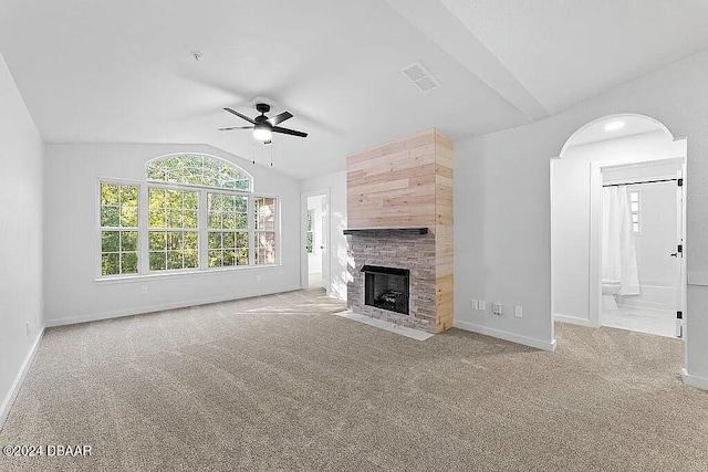 unfurnished living room featuring a fireplace, light colored carpet, vaulted ceiling, and ceiling fan