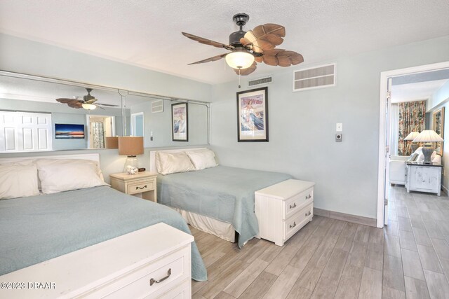 2301 S Atlantic Ave Unit 315, Daytona Beach, FL 32118 - bedroom with a textured ceiling, ceiling fan, and light hardwood / wood-style flooring