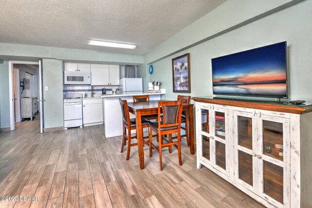 2301 S Atlantic Ave Unit 315, Daytona Beach, FL 32118 - dining room featuring light hardwood / wood-style floors and a textured ceiling