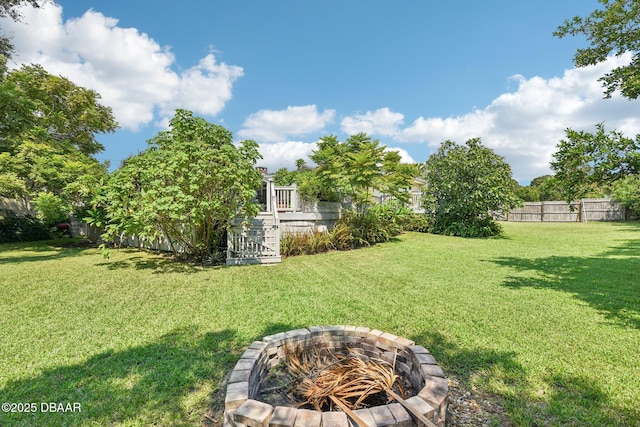 view of yard with fence and a fire pit