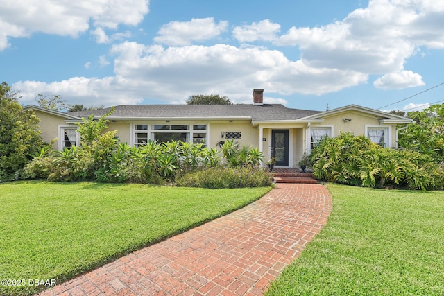 single story home featuring a front yard, a chimney, and stucco siding