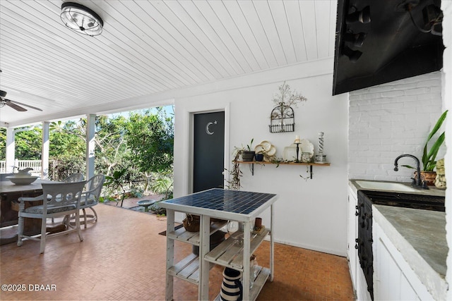 view of patio / terrace featuring outdoor dining area, a sink, and a ceiling fan