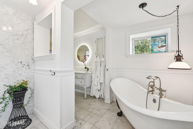 bathroom with a wainscoted wall, marble finish floor, a freestanding bath, and vanity