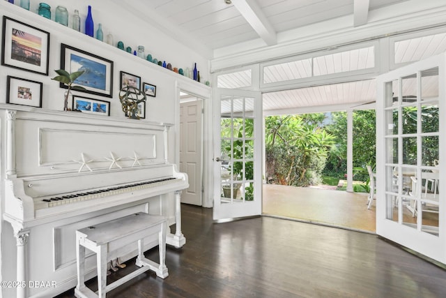 sitting room with beam ceiling, wood finished floors, and a wealth of natural light