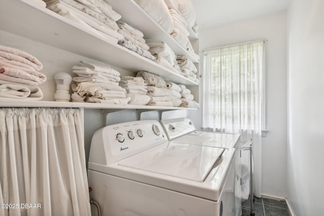 clothes washing area featuring baseboards, laundry area, and washer and dryer