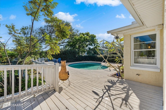 wooden terrace with a fenced in pool