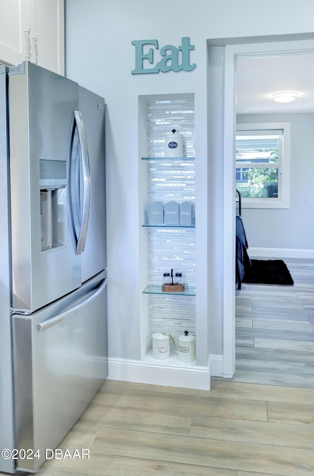 details with white cabinetry, stainless steel refrigerator with ice dispenser, and light hardwood / wood-style flooring